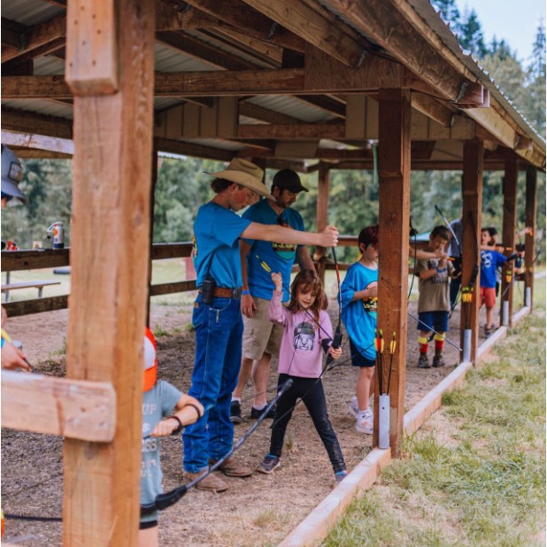 Pack 454 Scouts learning archery with a den leader