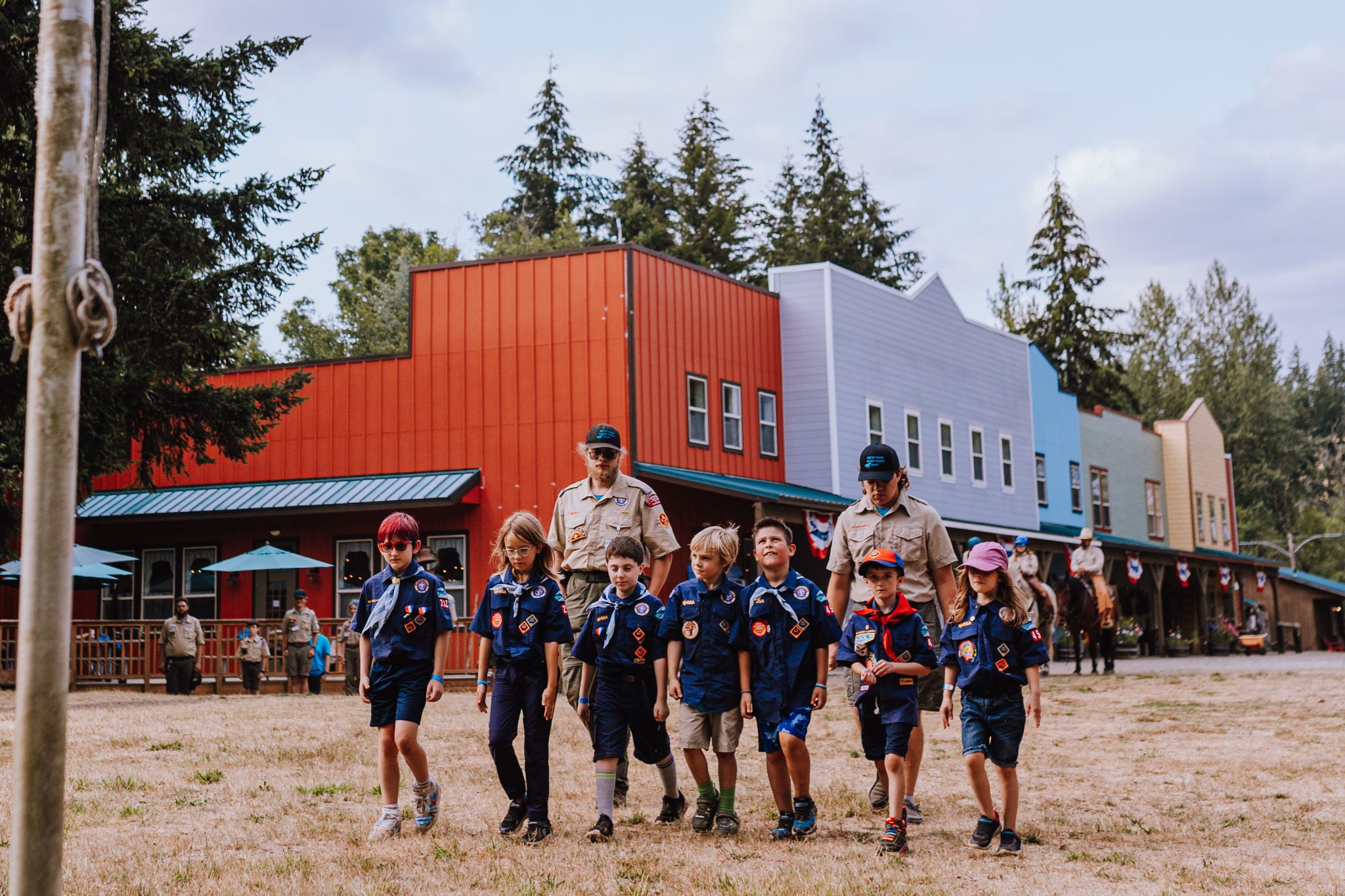 Pack 454 Cub Scouts and leaders walking together through camp