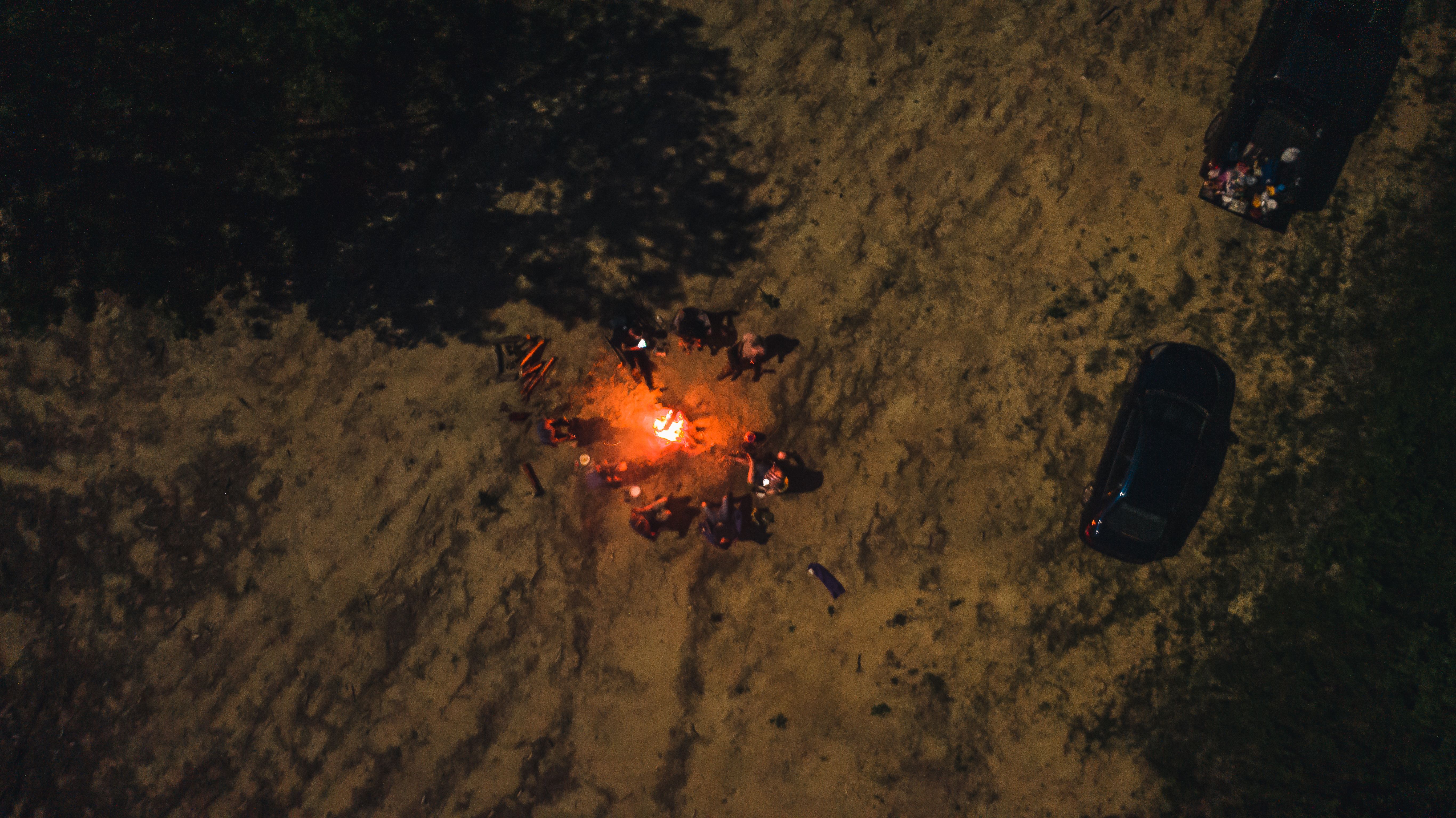 Group of people around a campfire in the forest at night