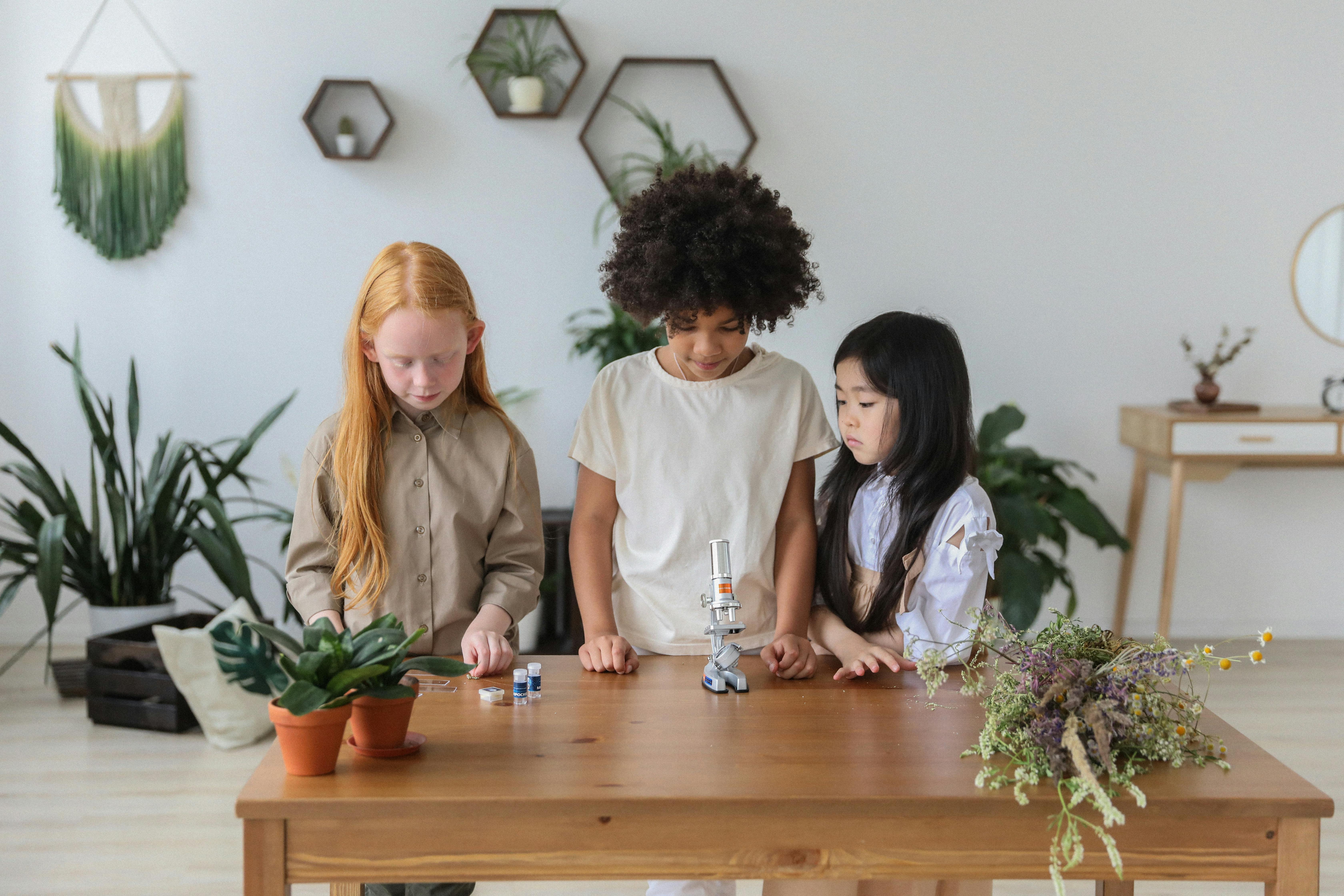 Children gathered around a microscope exploring science